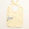 Back of ecru coloured baby bib. Two labels. No text or image