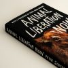 Front cover of 'Animal Liberation Now' book. Black with white writing and a picture of a calf