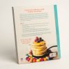 Back cover of 'Taste for Life' cookbook. Image of a stack of pancakes with berries on top. Blurb writing in orange and blue writing