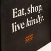 Black shopper bag with orange Animals Australia logo and a quote - "Eat, shop, live kindly"